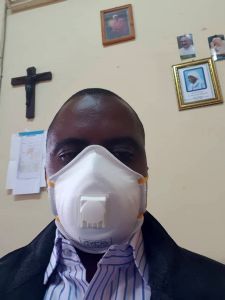 Father Celestine Kapinga, Finanzdirektor der Diözese Mbinga, trägt als Schutzmaßnahme gegen das  Coronavirus eine Schutzmaske.