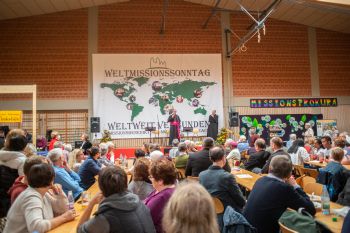 Rund 1500 Besucherinnen und Besucher kamen zum Weltmissionssonntag, um die zehnjährige Partnerschaft der Bistümer Würzburg und Óbidos zu feiern und den "Markt der Möglichkeiten" zu erkunden. Auf dem Podium begrüßt Bischof Dr. Franz Jung die Besucher. 