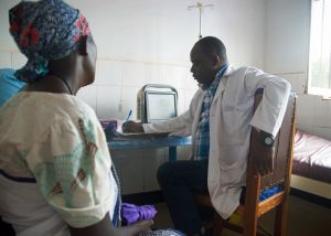 Für viele Menschen ist die Mobile Klinik die einzige Möglichkeit für eine schulmedizinische Versorgung. Das Bild zeigt Dr. Maurus Ndomba mit einer Patientin.