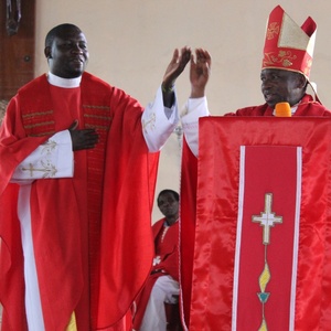 Bischof John Ndimbo führt Pater Dennis Aura CMM als Pfarrer ein